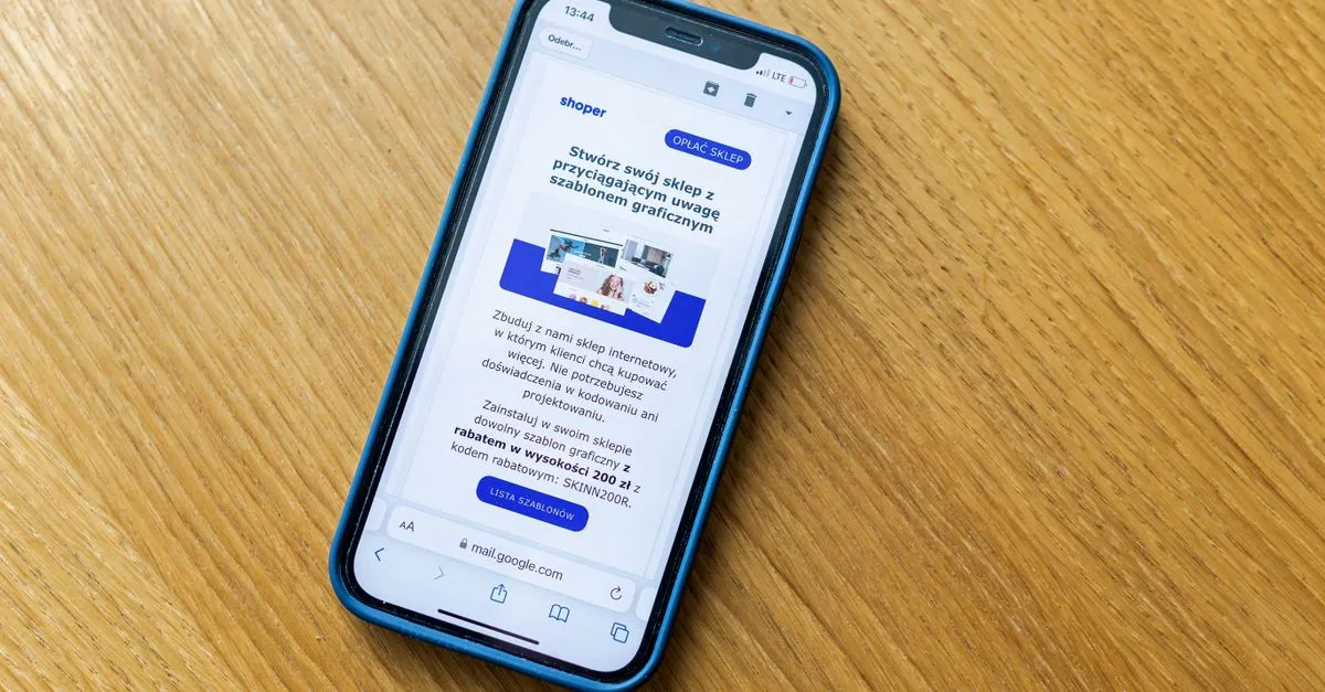 Close-up of a smartphone on a wooden table showing an online shopping webpage.