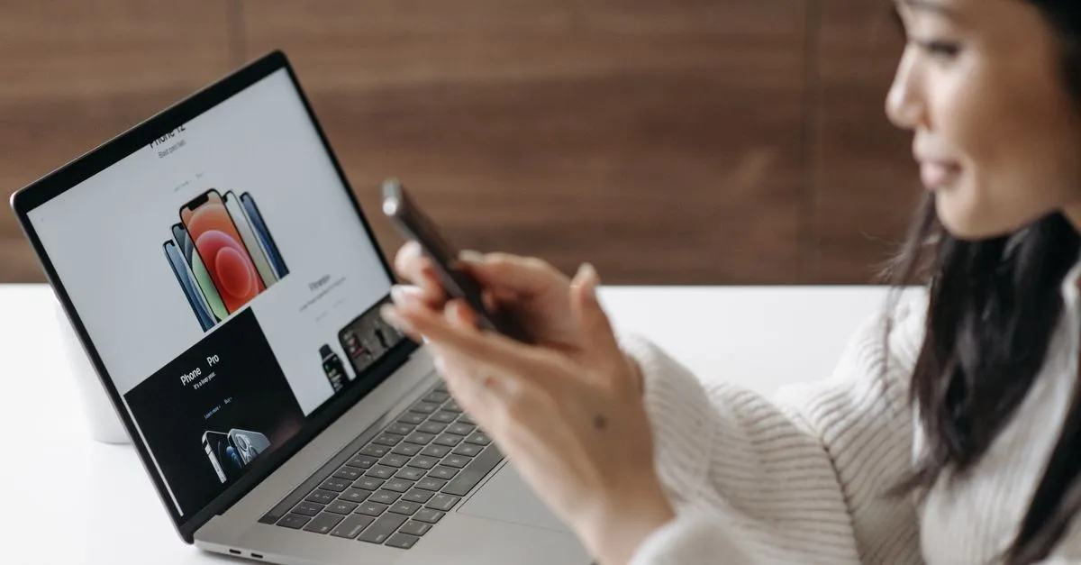 Asian woman shopping online with a laptop and smartphone at home.