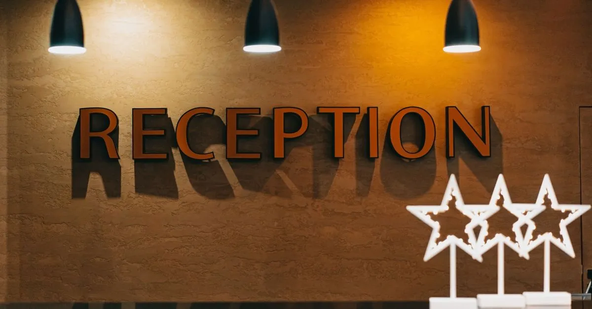 Osvětlená cedule Reception se čtyřmi hvězdami v hotelu