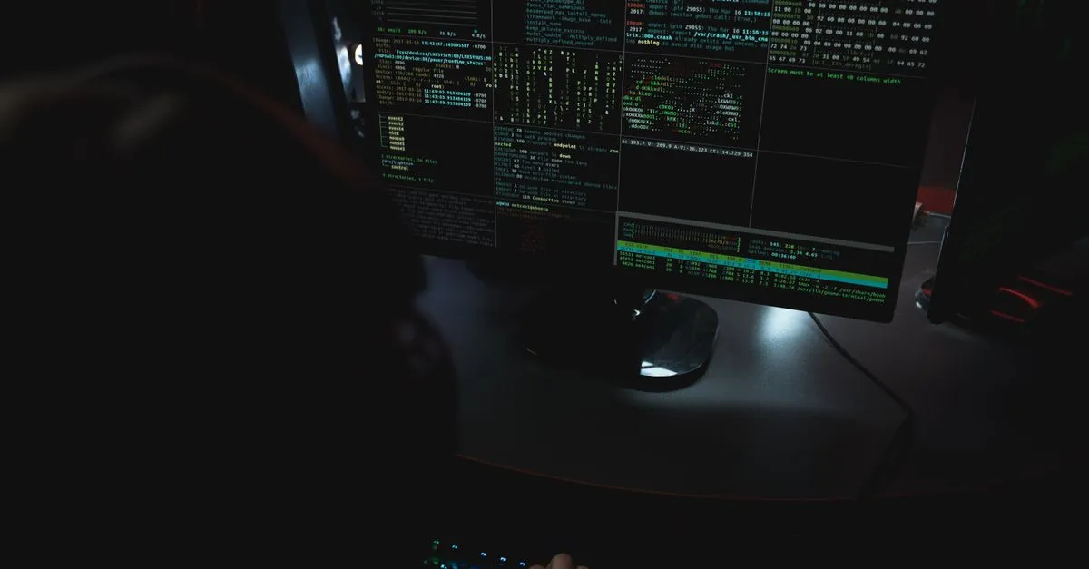 Dark room setup with code displayed on PC monitors highlighting cybersecurity themes.