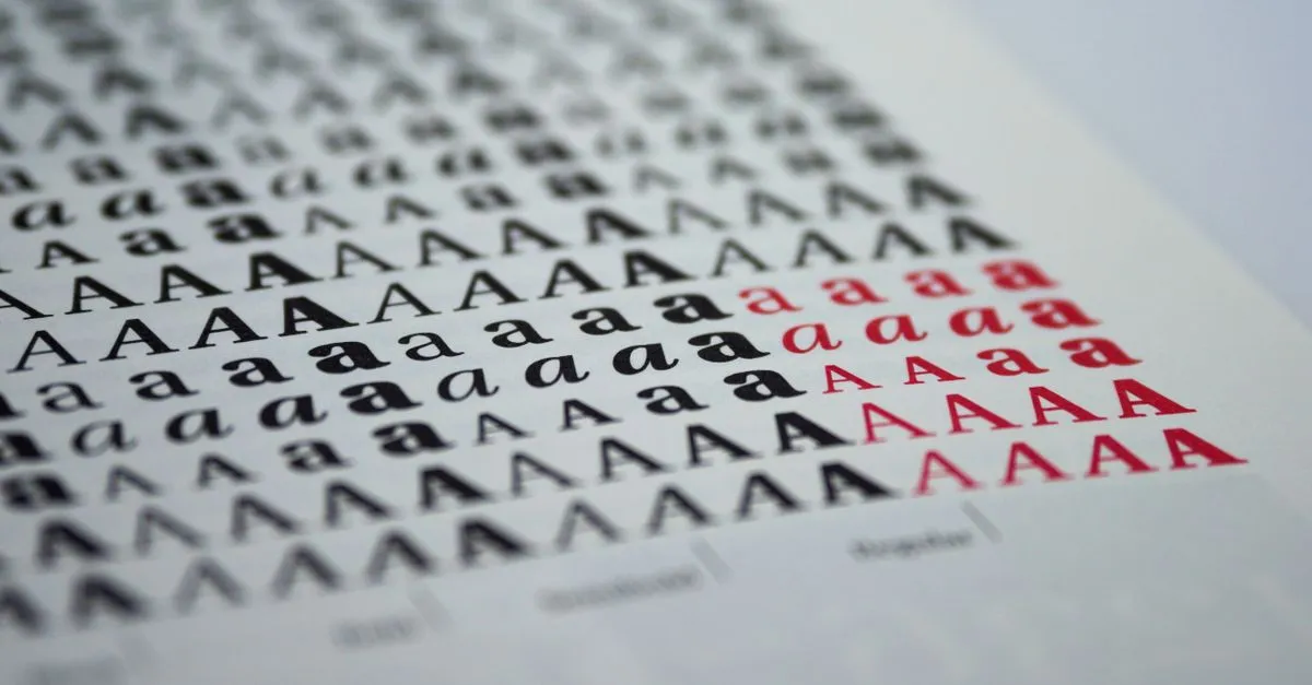 Close-up view of various printed letter 'A' styles in black and red on white paper.
