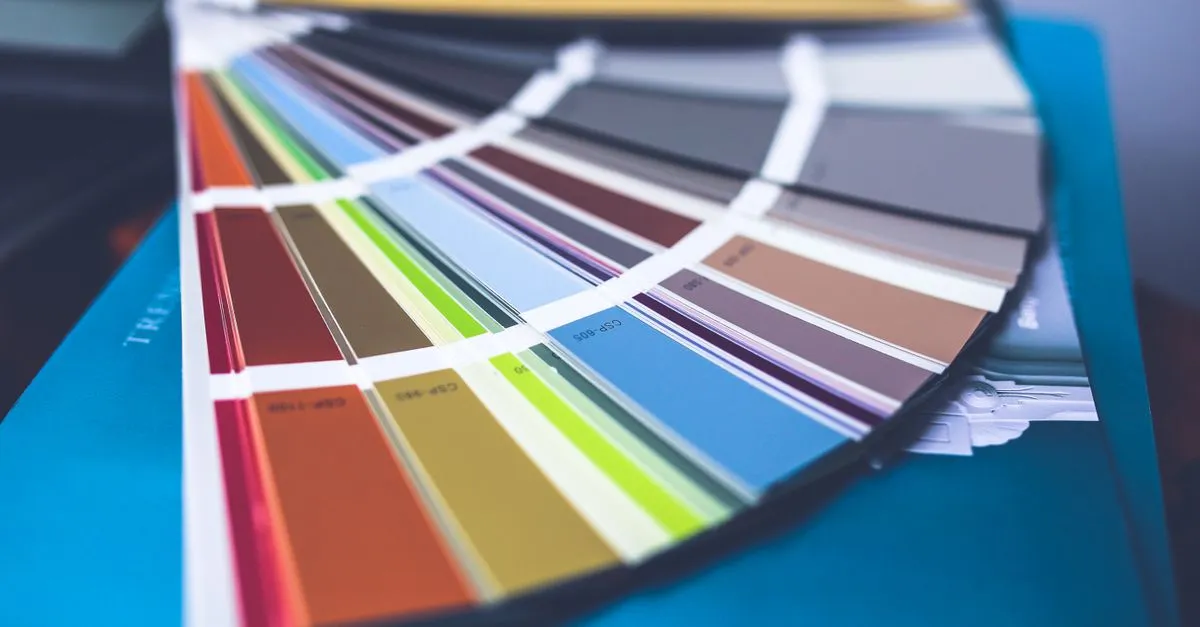 A collection of colorful paint swatches spread out showcasing a variety of hues.