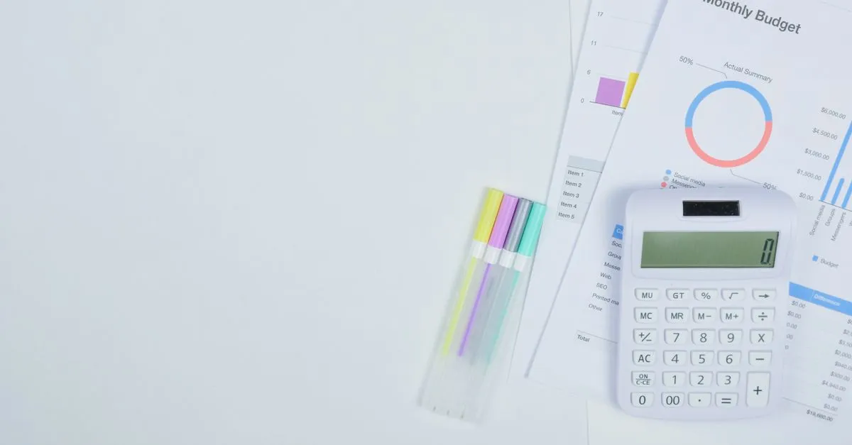 A desk with a calculator and budget planning documents