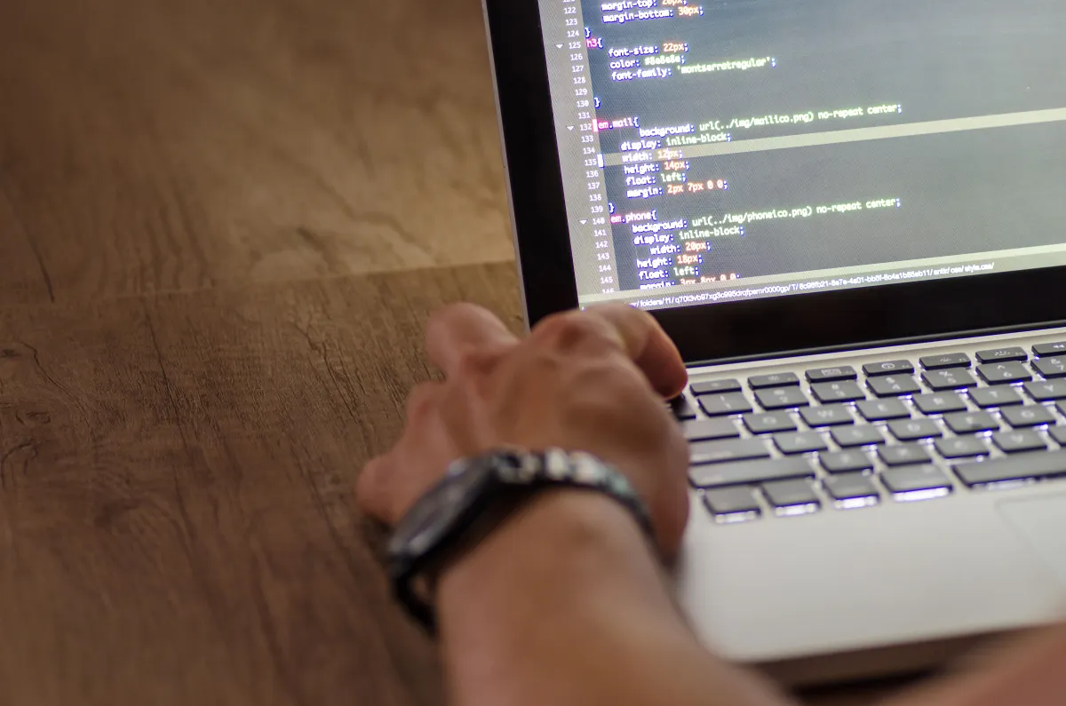 Programmer hands typing code on a laptop keyboard
