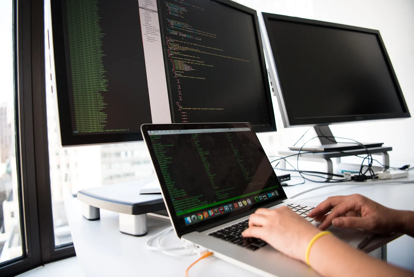 Developer reviewing website code on office monitors
