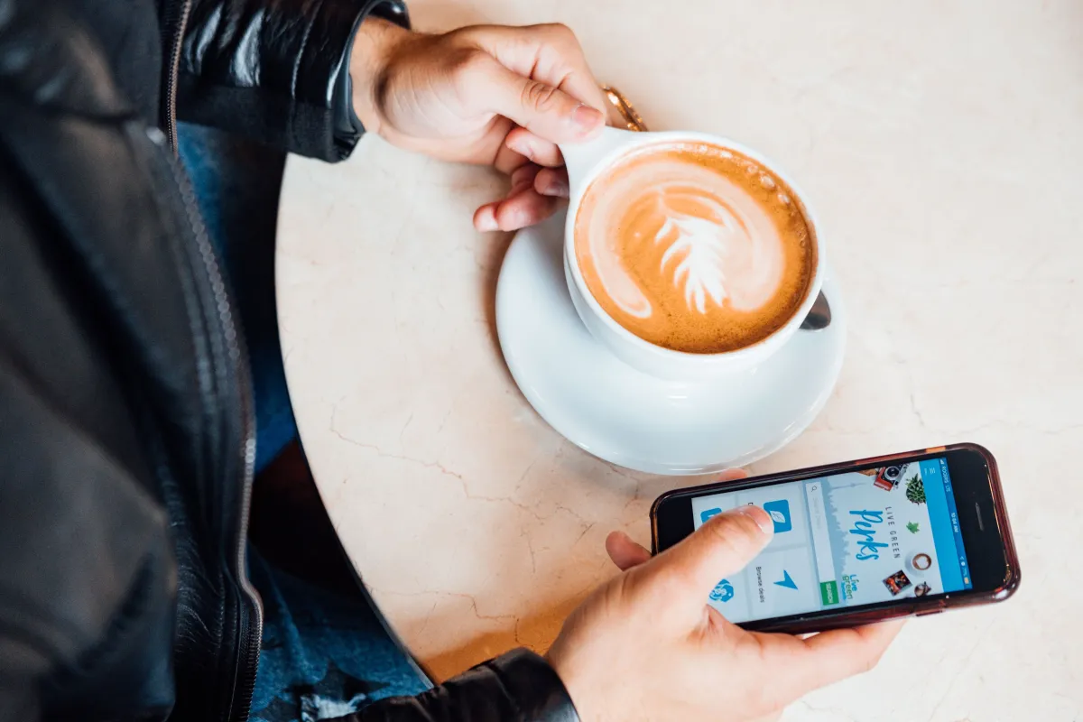 Guest using a smartphone at a cafe table